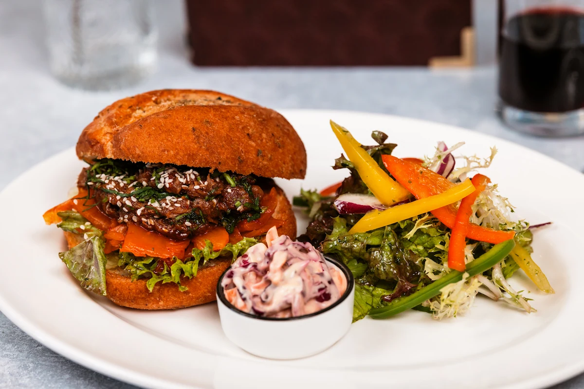 A burger with side salad and coleslaw