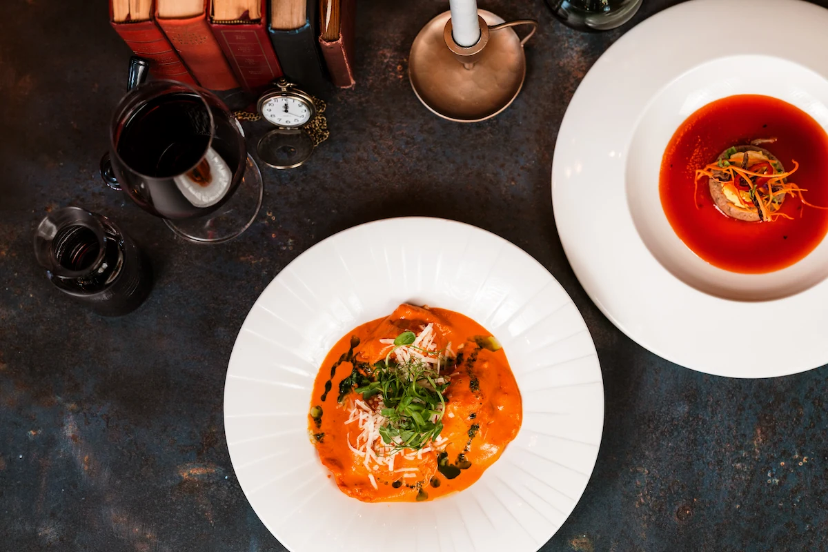 Two plates of food, with red and orange sauces