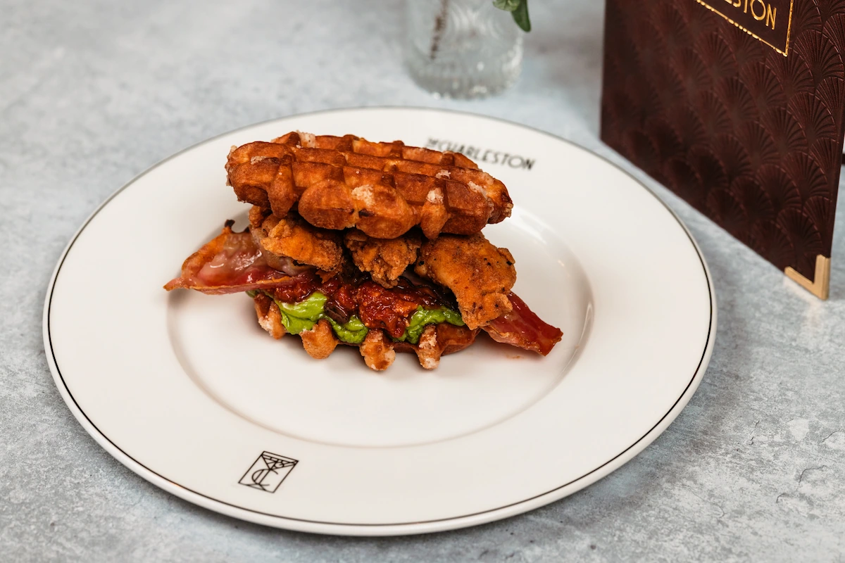 A chicken, bacon and guacamole sandwich with waffles for bread